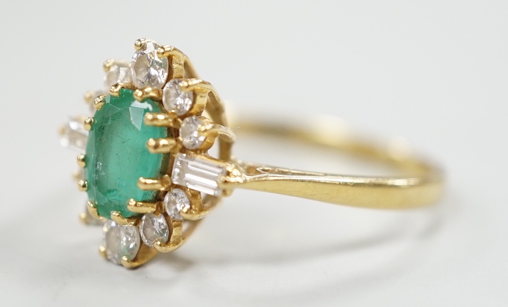 A modern 18ct gold, single stone oval cut emerald and round and baguette cut diamond cluster set ring, size P/Q, size 3 grams.